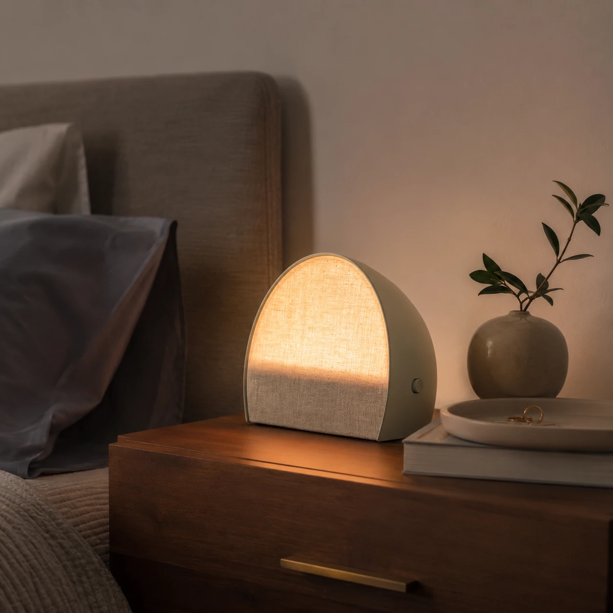 Hatch Restore 2 in a minimalist bedroom evening setup with a soft ambient glow Hatch Restore 2 in a minimalist bedroom evening setup with a soft ambient glow