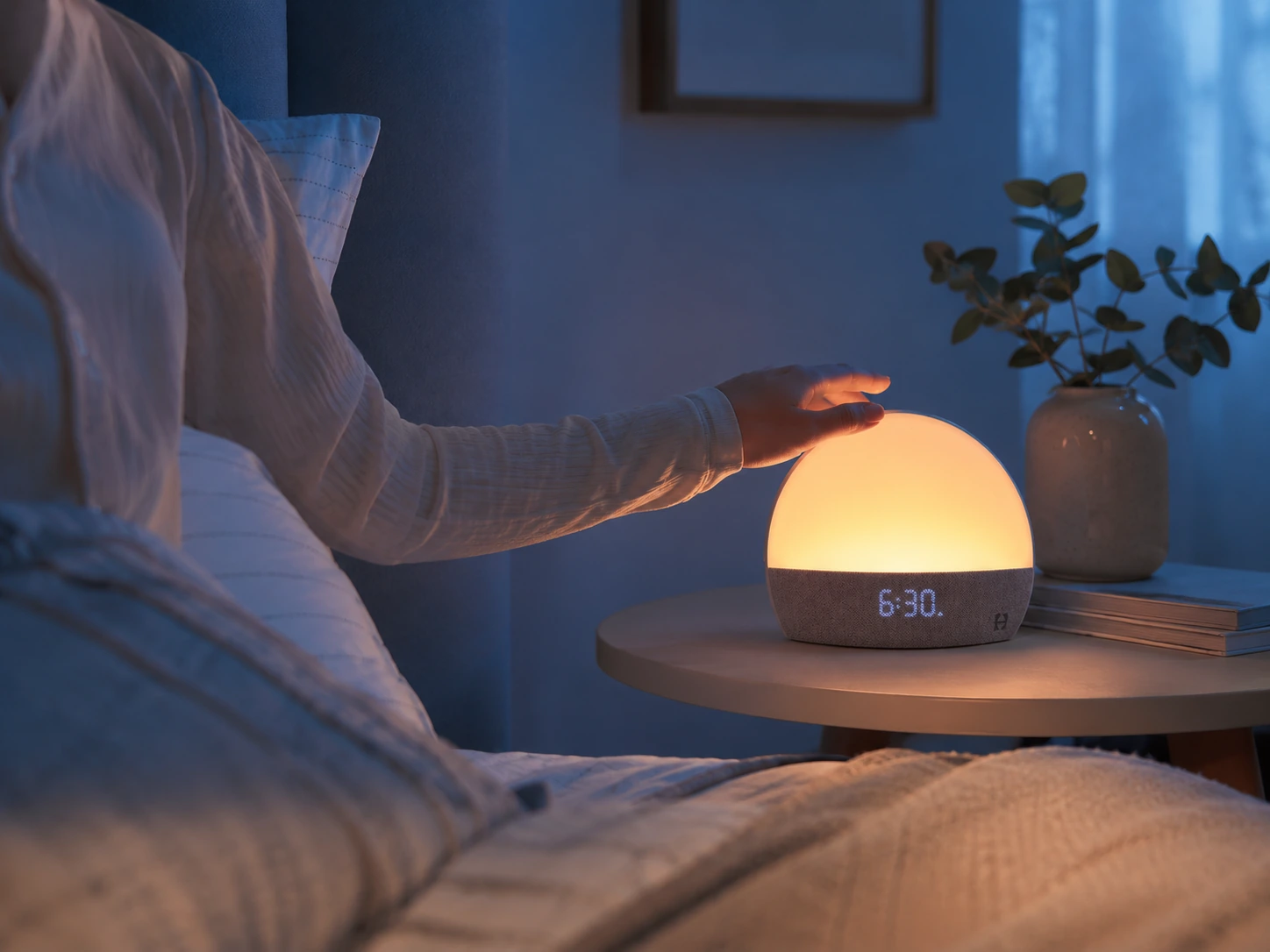 Hand tapping Hatch Restore during a gentle sunrise wake-up routine Hand tapping Hatch Restore during a gentle sunrise wake-up routine