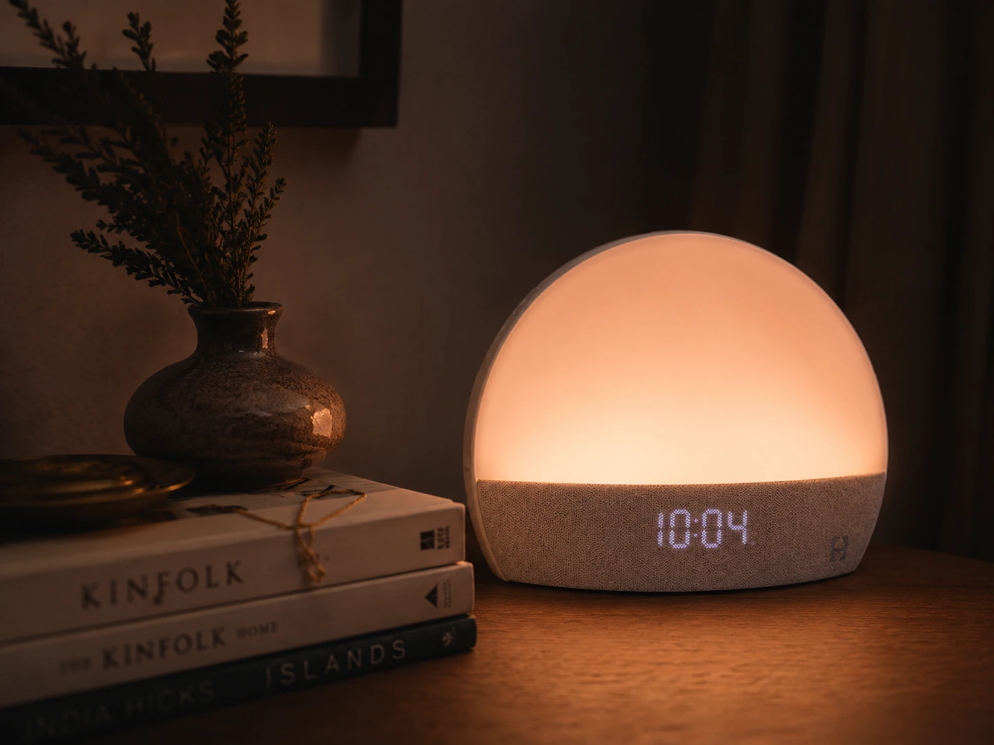 Hatch Restore Smart Alarm Clock casting a soft ambient glow on a nightstand Hatch Restore Smart Alarm Clock casting a soft ambient glow on a nightstand